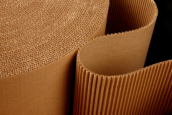 close up shot of corrugated packing material uncurling on black background